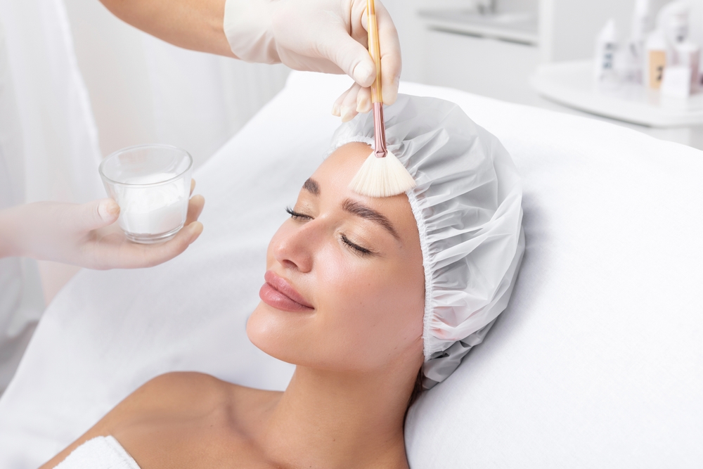 Woman receiving facial chemical peel therapy for skin rejuvenation at medical spa or beauty clinic.