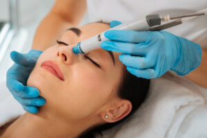 Close-up of a serene, beautiful woman receiving a Hydrafacial in preparation of an event.